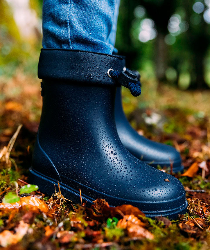 A short unisex wellie by Igor, style Bimbi Euri, in khaki green with toggle fastening. Lifestyle image.