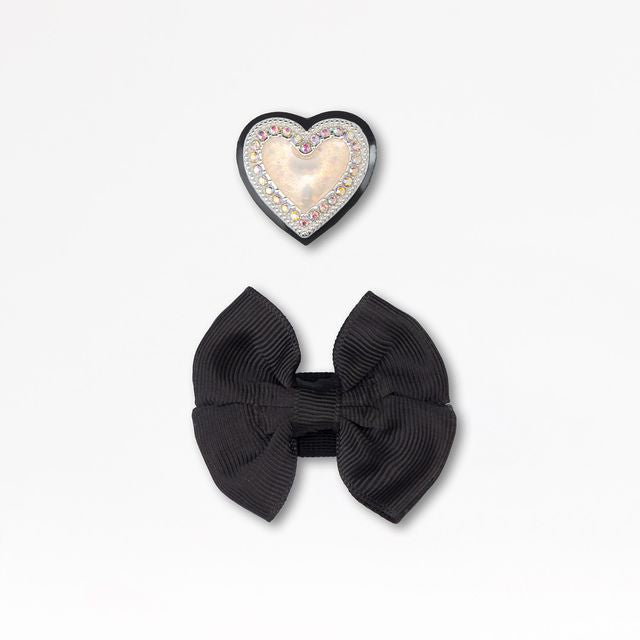 A pair of detachable shoe accessories by Lelli Kelly, style LKSO8467CVR Sabrina. Heart embellished charm and fabric bow charm.