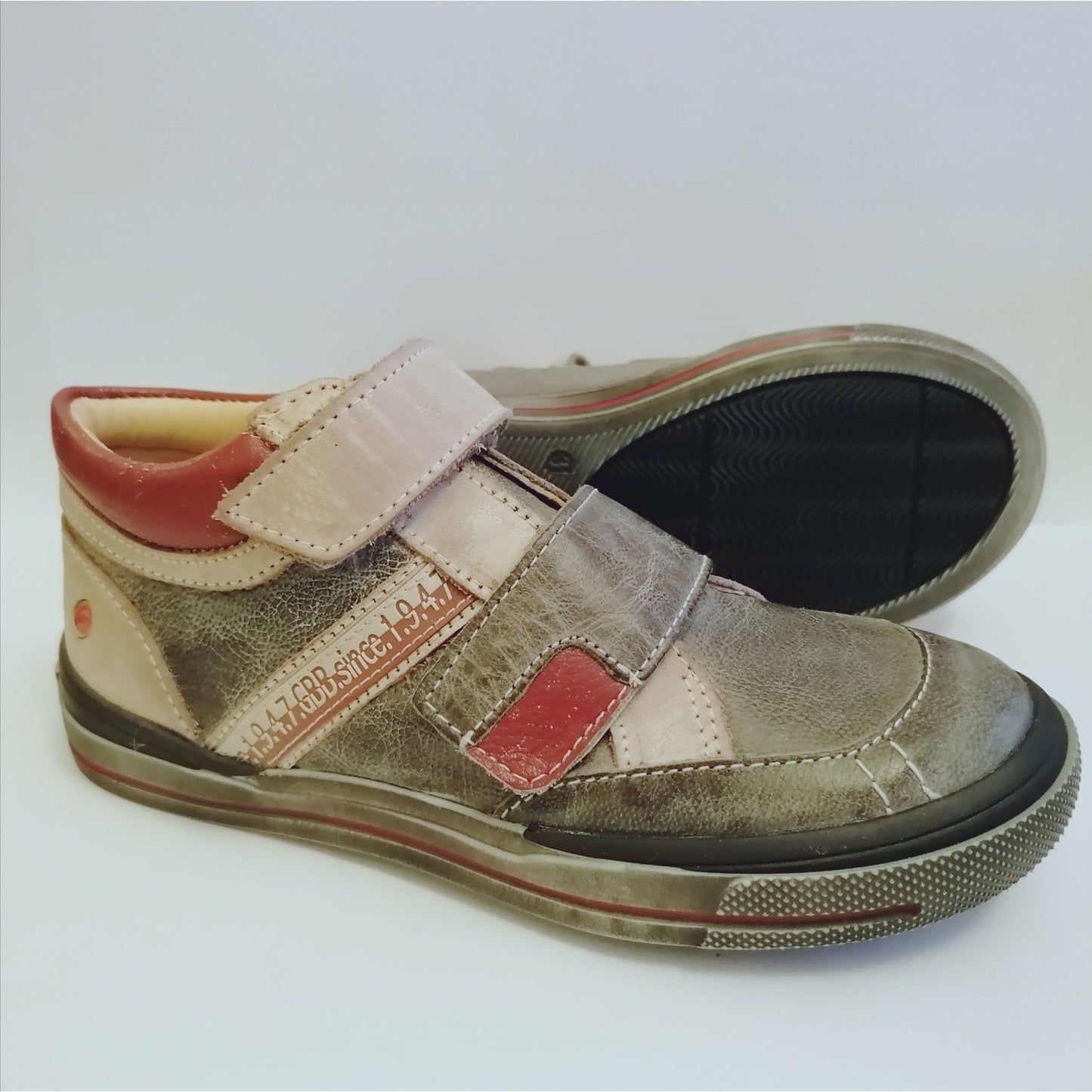 A boys boot by GBB, grey/off white/red distressed leather, double velcro and rubber toe. Right side view, left view of sole.