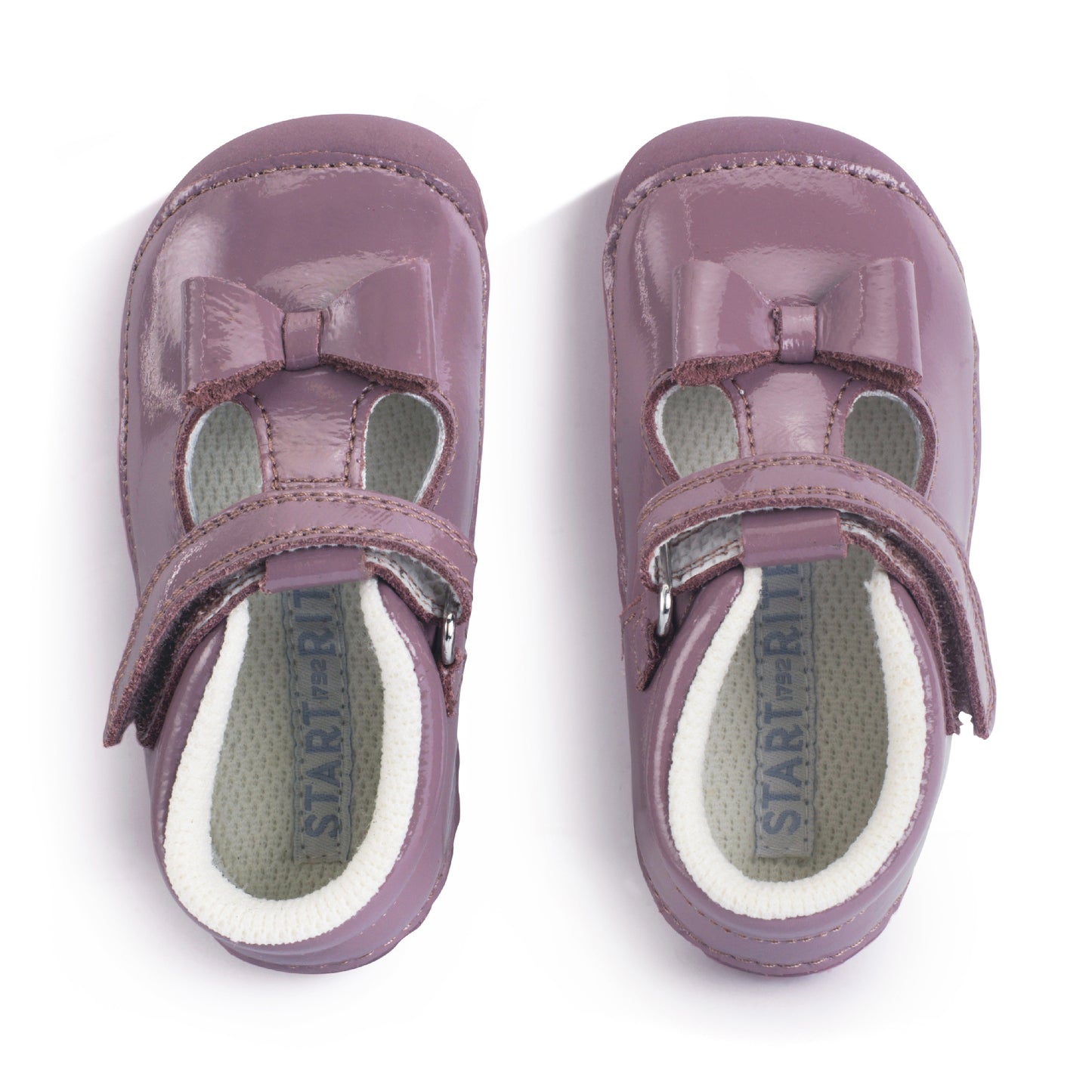 A girls shoe by Start-Rite, stye Wiggle, in mauve with bow detail, with heel and toe bumpers and t bar with velcro strap. Top view of pair