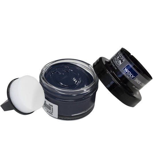 A open pot of dark blue shoe cream by Woly, shown with sponge applicator and lid. Front view.