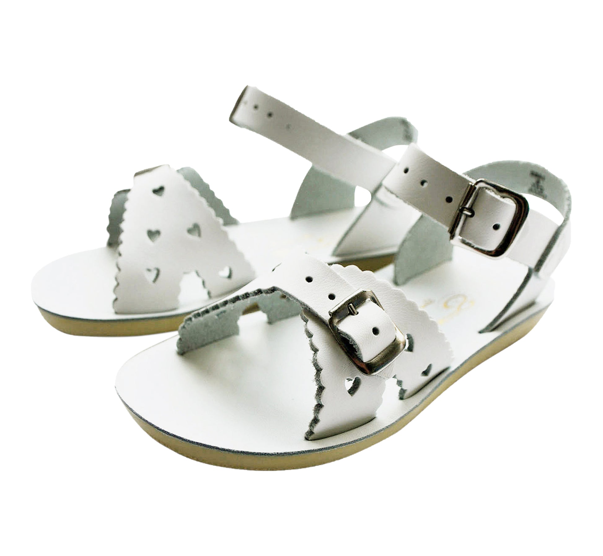 A girls sandal by Salt Water Sandal in white with double buckle fastening across the instep and around the ankle. Featuring scallop edge and punched out heart detail. Pair view.