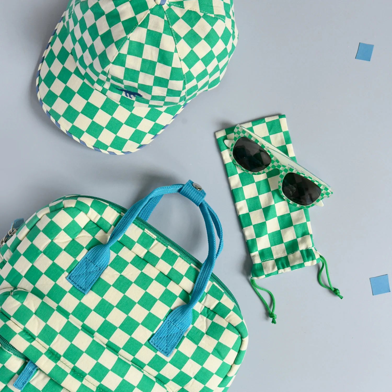 A selection of green and white check accessories by Rockahula included a bag, cap and sunglasses with case on a grey background