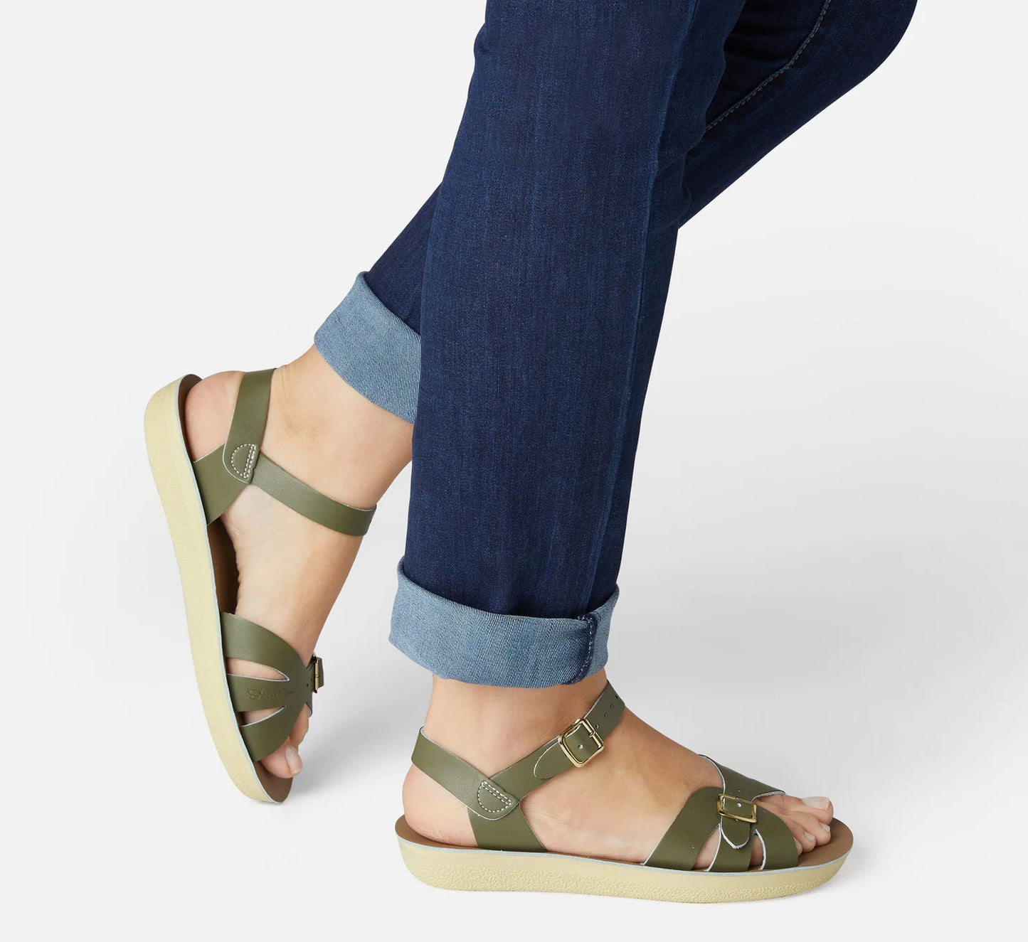 An adult sandal by Saltwater, style Boardwalk in olive with buckle strap. Image of woman modelling the sandals
