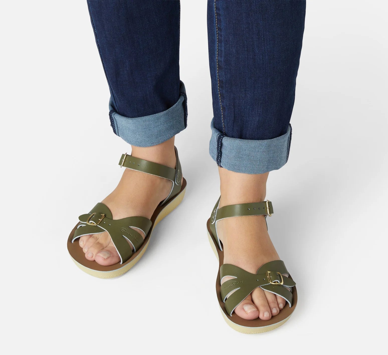 An adult sandal by Saltwater, style Boardwalk in olive with buckle strap. Front image of woman modelling the sandals