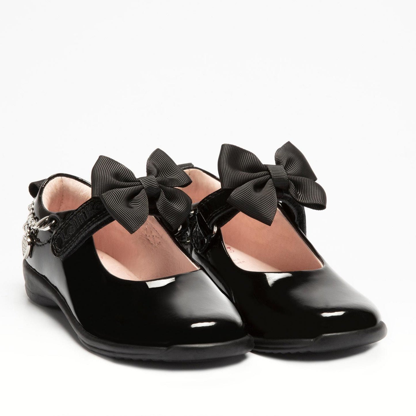 A pair of girls Mary Jane school shoes by Lelli Kelly, style LK8219 Jewel, in black patent leather with velcro fastening and detachable fabric bow and bracelet. Angled view.