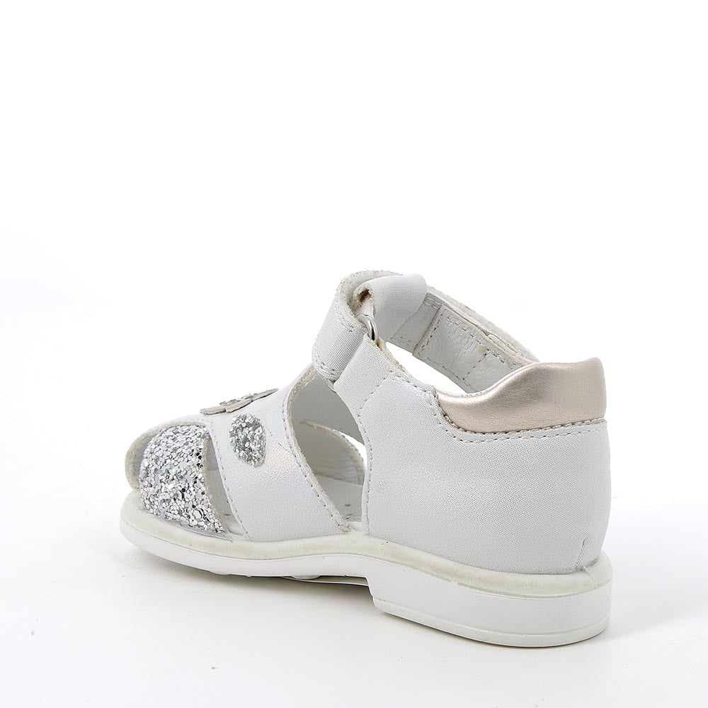 A girls closed toe sandal by Geox, style 3859111, in white and silver with a velcro strap. Inner side view.