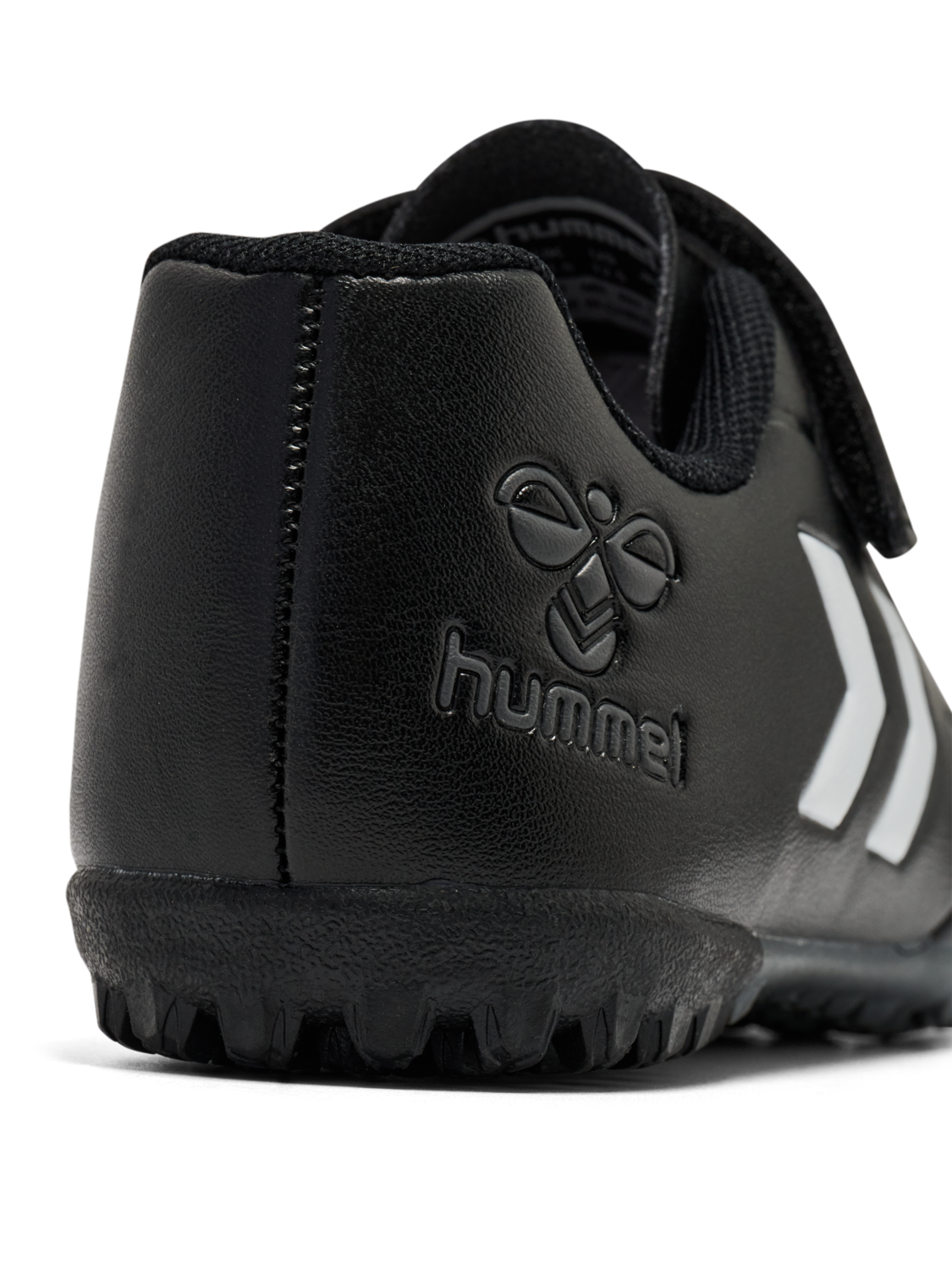 A astro turf football boot by Hummel, style Top Star Turf JR 228343-2267 in black with white trim with velcro fastening. Angled view of heel.