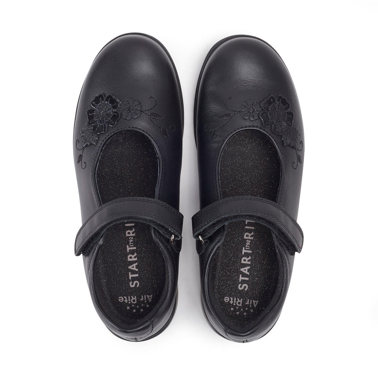 A pair of girls Mary Jane school shoes by Start Rite, style Wish, in black leather with flower motif and velcro fastening. View from above