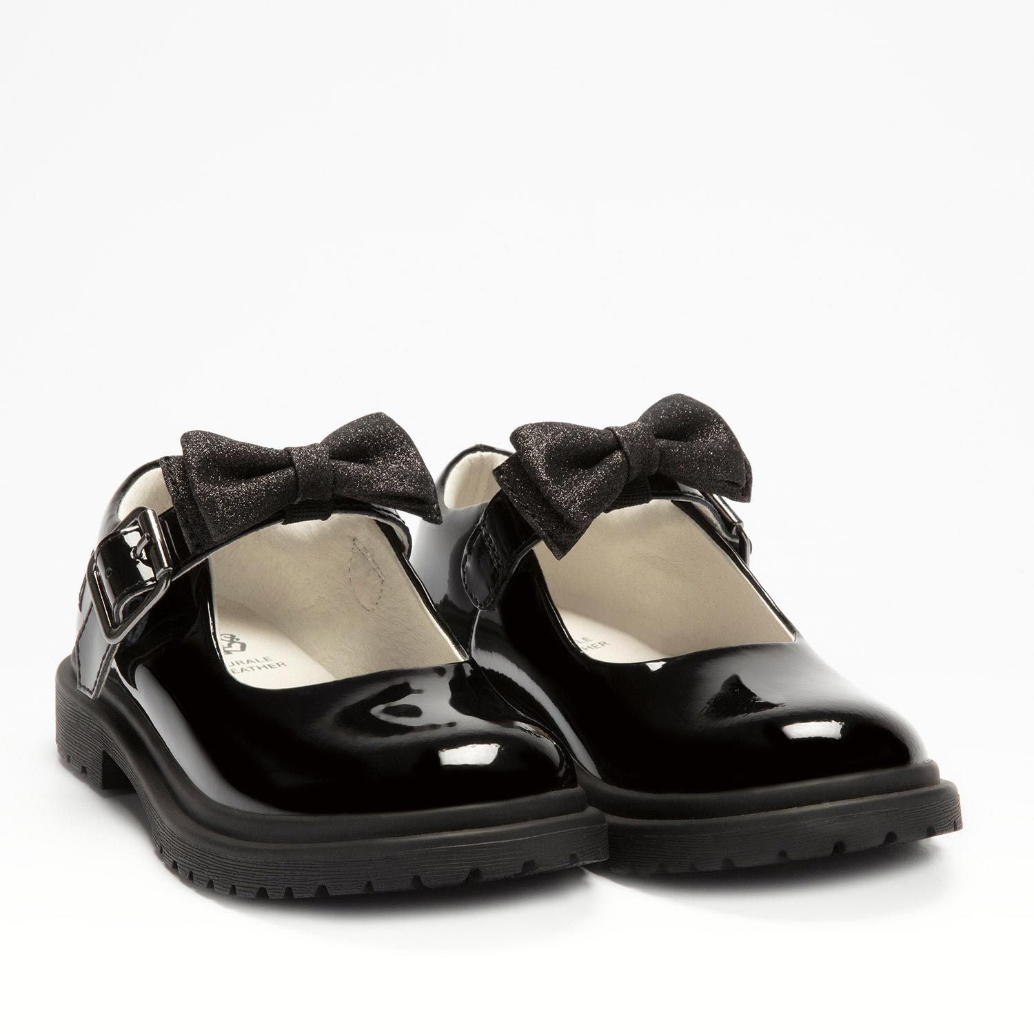 A pair of girls chunky Mary Jane school shoes by Lelli Kelly, style LK8359 Mollie, in black patent leather with buckle fastening and detachable fabric bow. Angled view.