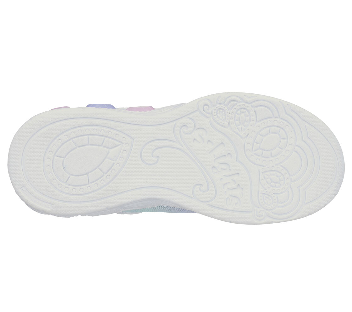 A girls light up trainer by Skechers, style Princess Wishes, in lilac sequin/multi with bungee lace and velcro fastening. View of white sole.