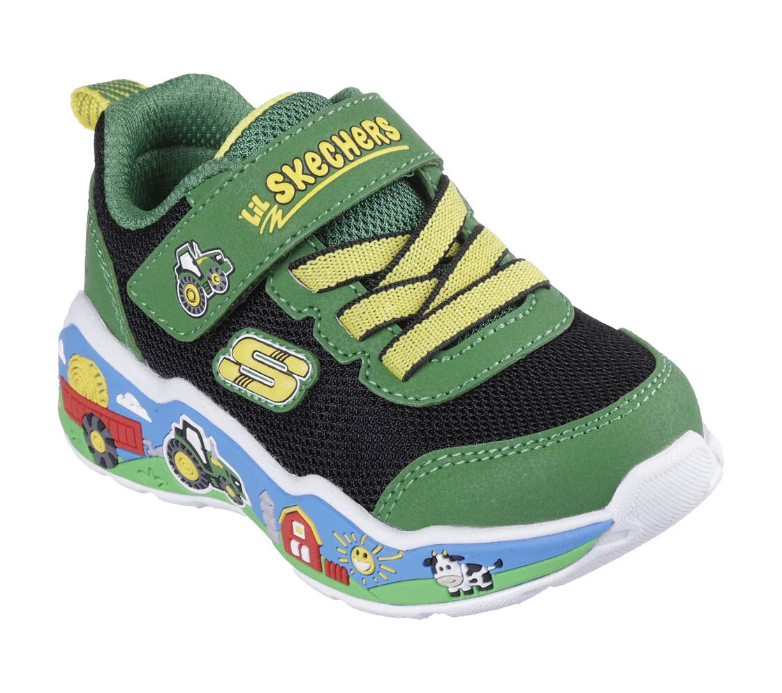 A girls trainer by Skechers, style Play Scene Barn Squad, in green and black set on blue sole with farm yard  motifs. Velcro and elastic lace fastening. Angled view.