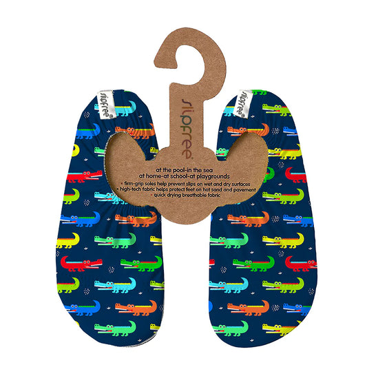 A pair of swim shoes by Slipfree, style Amazon in dark blue with multicoloured crocodile design, hanging on cardboard hanger