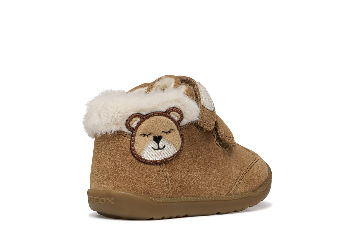 Geox suede ankle boot in brown, with two Velcro straps, bear detailing, fur lining and a tan rubber sole. Angled back view of right shoe. 