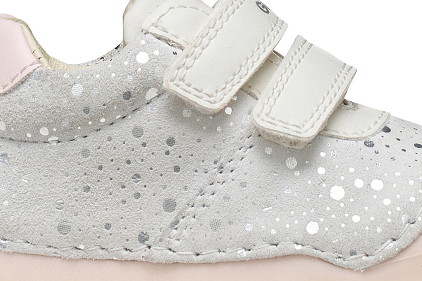A girls pre-walker shoe by Geox, style Tutim in white/pink with silver speckled design, two velcro straps and toe and heel bumpers. Zoomed image of side