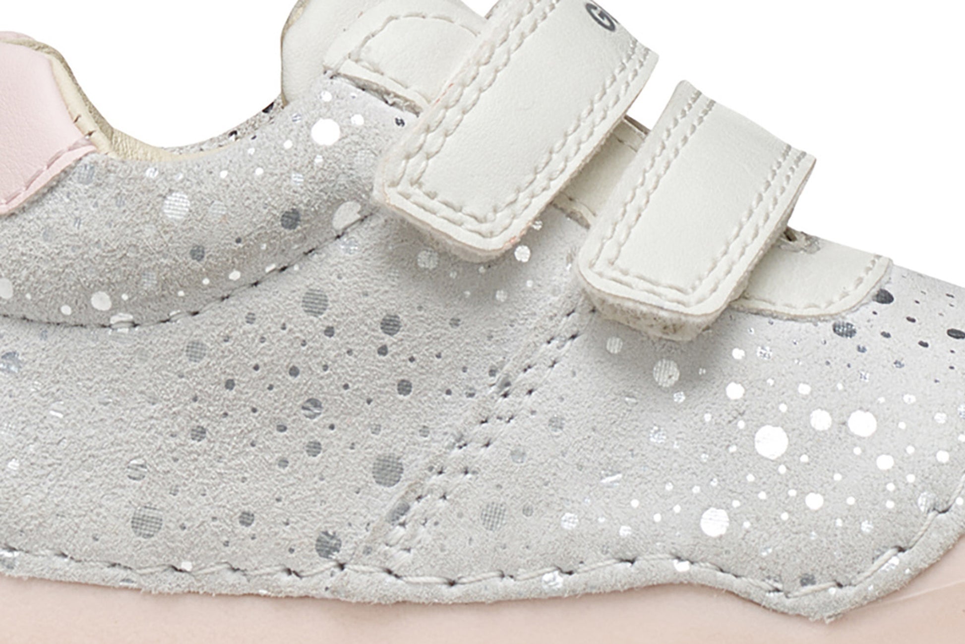 A girls pre-walker shoe by Geox, style Tutim in white/pink with silver speckled design, two velcro straps and toe and heel bumpers. Zoomed image of side