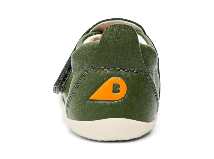 A pre-walker by Bobux, style XP Go, in forest green with velcro strap. View of the back with contrast orange logo.