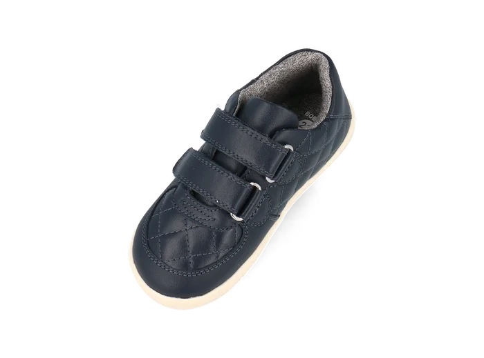 A boys casual shoe by Bobux, style Stitch, in navy leather ,with stitch detail and double velcro fastening. Angled view.