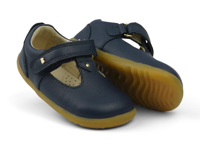 A unisex first shoe by Bobux, style Louise, a velcro T-bar in navy. Angled view of pair, one showing gum sole.
