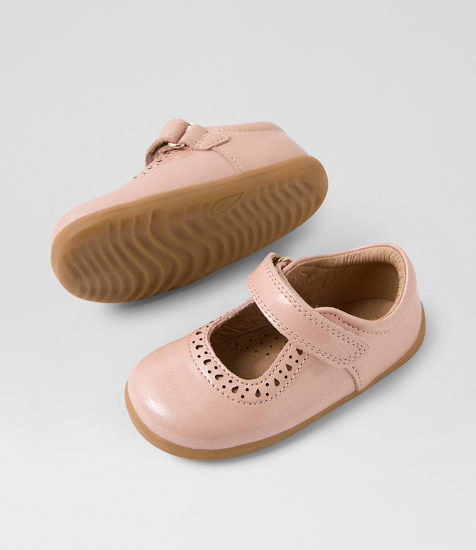 A girls casual shoe by Bobux, style Lola (Step Up) in Cameo Rose with velcro strap, cut out pattern detail and light brown sole. View of pair with one sole showing