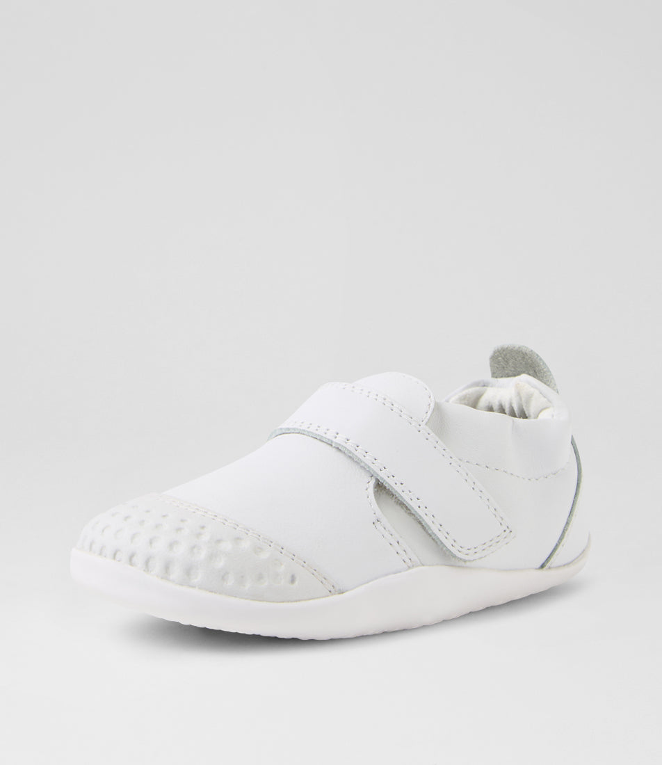 A unisex pre-walker shoe by Bobux, style Xplorer in white. With a velcro strap and front toe bumper. Angled front view
