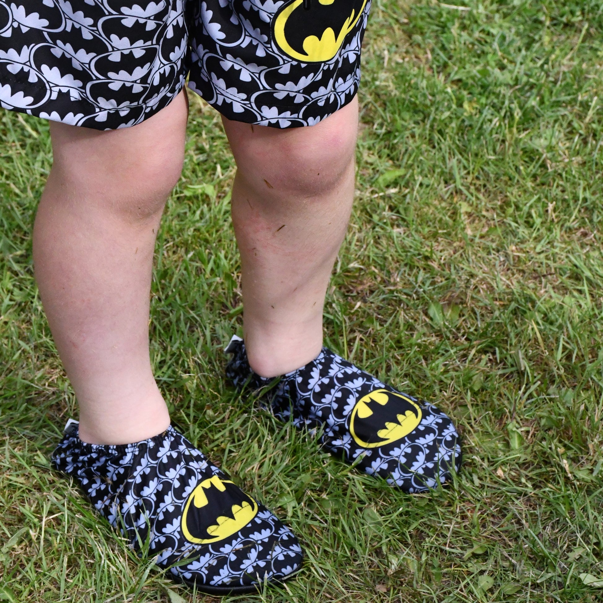 A non-slip shoe by Slipfree in collaboration with Warner Brothers, style Bruce (Batman) in grey black and yellow Batman print.  Lifestyle image.