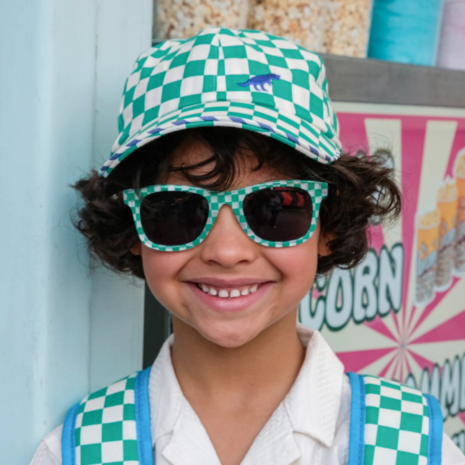A boy wearing green and white check sunglasses and cap by Rockahula