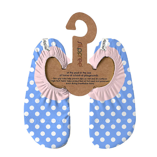 A pair of water shoes by Slipfree, style dotty in blue with white sots and pink ankle, hanging on cardboard hanger. 