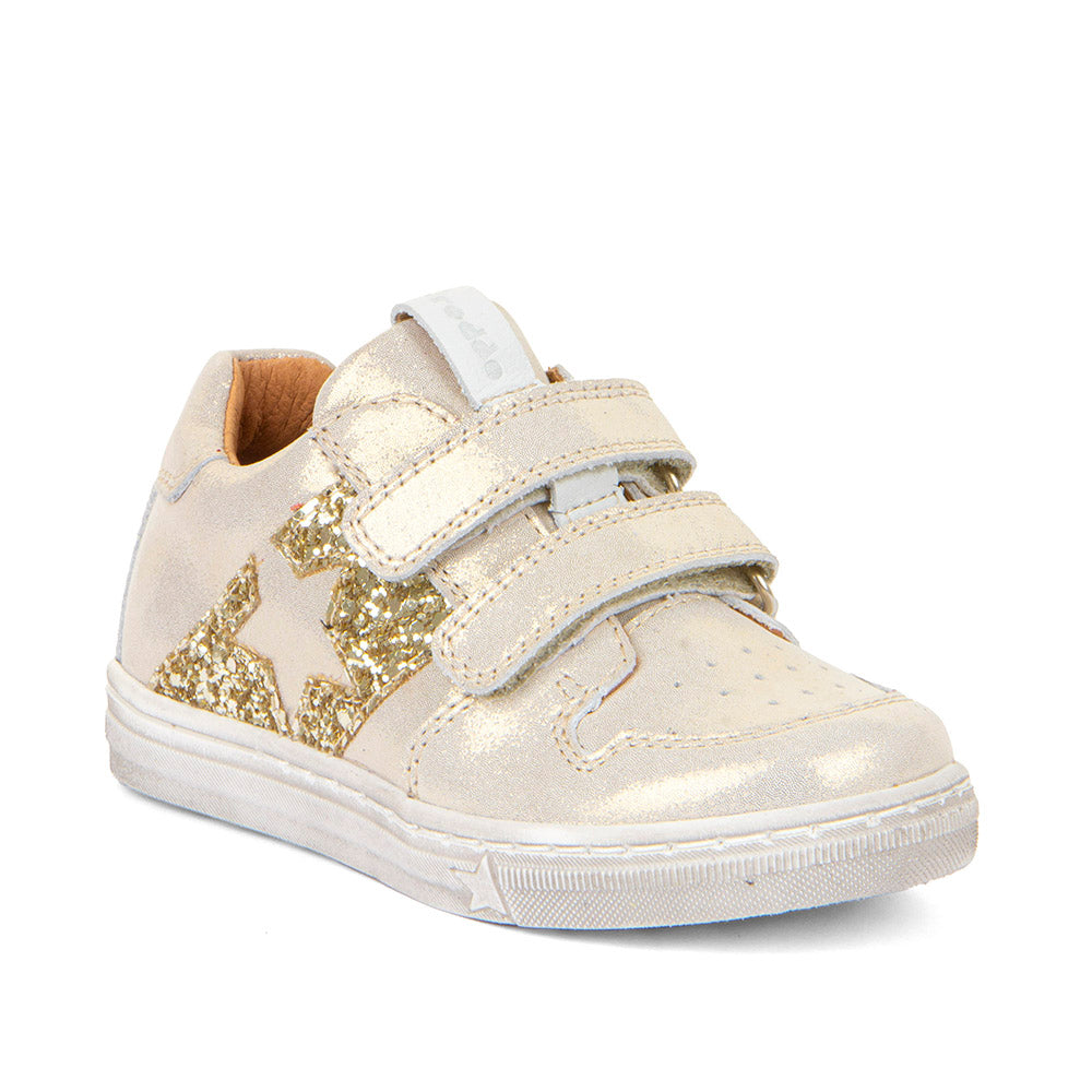 A girls casual occasion shoe by Froddo, style G2130315-11 Dolby, in light gold metallic with gold sequin block and star detail, double velcro fastening. Angle view.