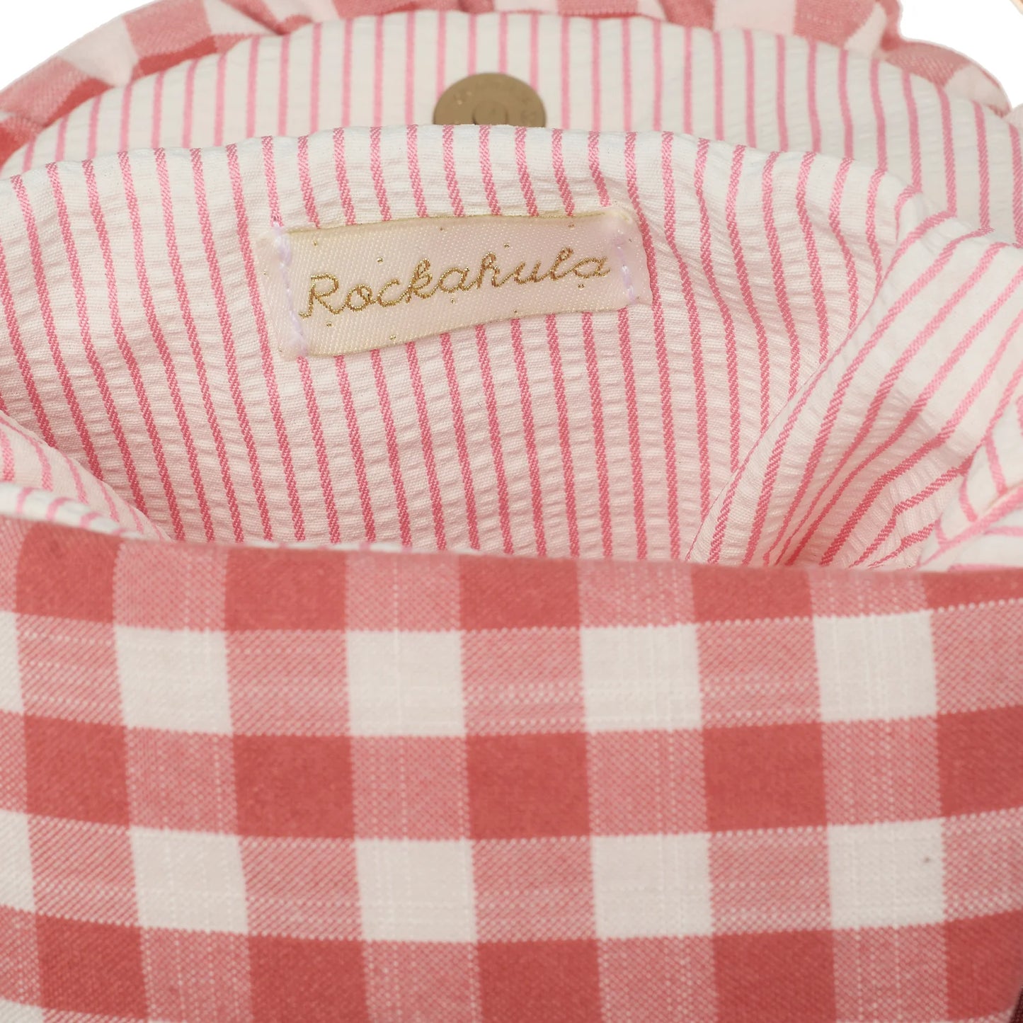 Close-up of a pink and white checkered bag with a 'Rockahula' label.