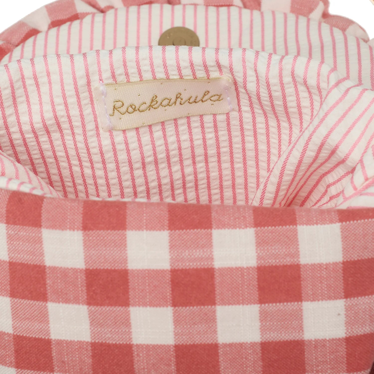 Close-up of a pink and white checkered bag with a 'Rockahula' label.