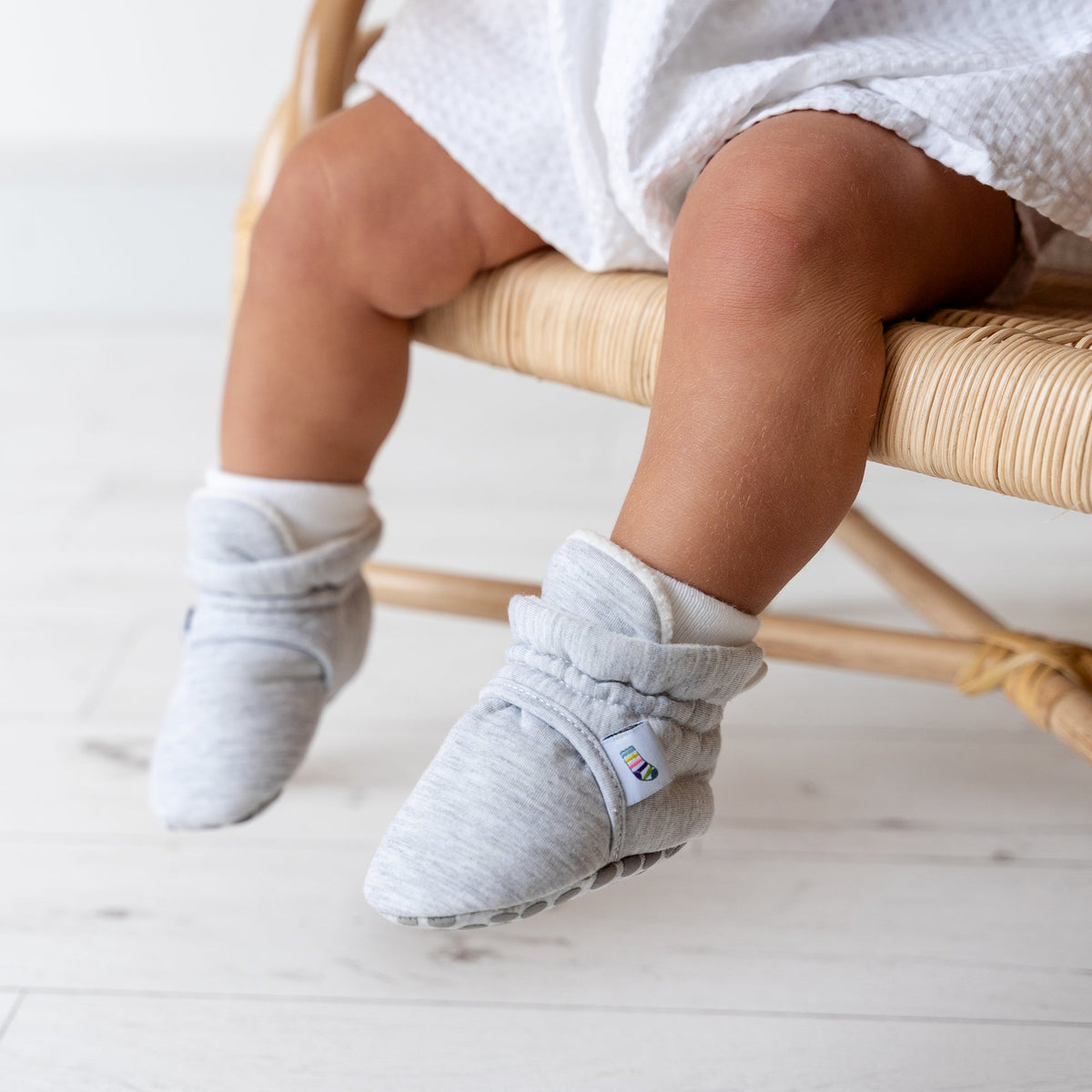 Grey bootie non slip slipper with pull toggle for a perfect fit for babies. Lifestyle view.