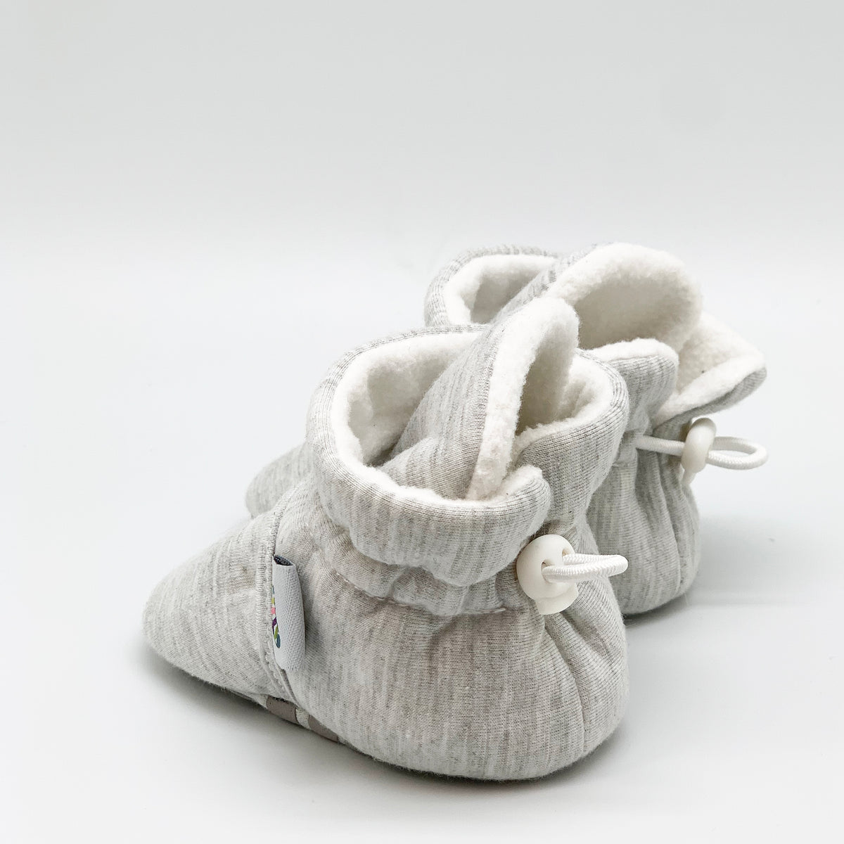 Grey bootie non slip slipper with pull toggle for a perfect fit for babies. Back view.