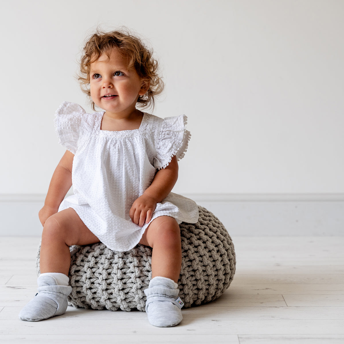Grey bootie non slip slipper with pull toggle for a perfect fit for babies. Little girl view.