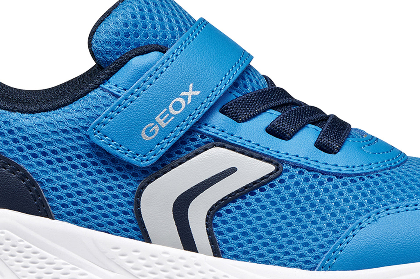A boys trainer by Geox, style Sprintye in blue/navy with velcro strap and elastic laces and grey detail on side. Zoomed view of side detail and logo on strap