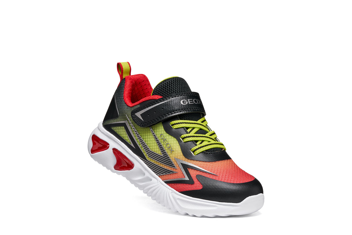 Geox boy's trainer in the style Assister, in red, yellow and black with a Velcro strap, lights and a white sole. Right side view.