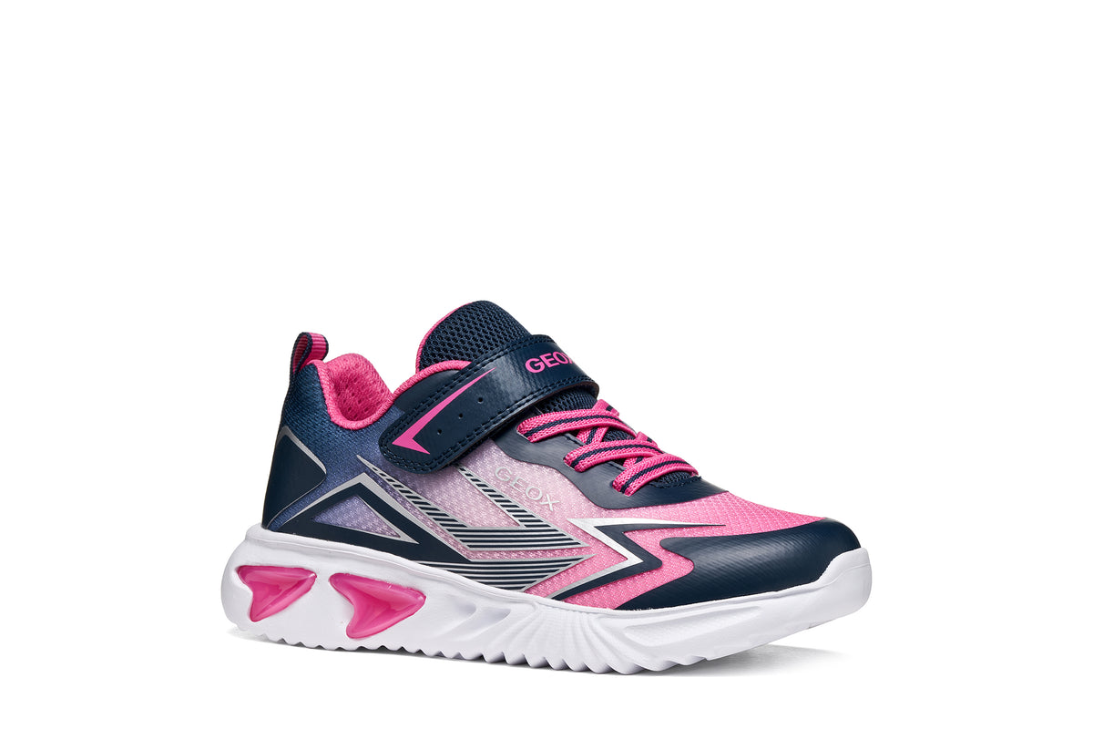 Geox girls trainer in the style Assister in navy, pink and white with a Velcro strap, lights and a white sole. Angled right side view.