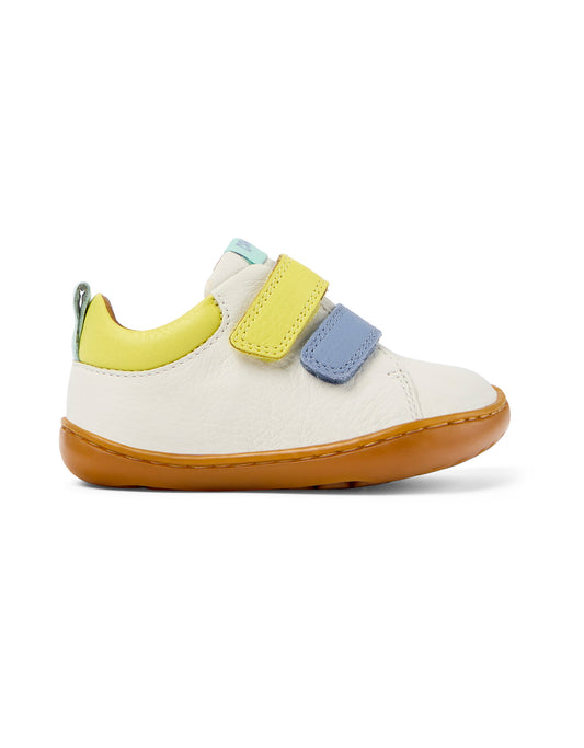 A unisex shoe by Camper, style Peu, in white with blue and yellow velcro straps and detail. Right side view.
