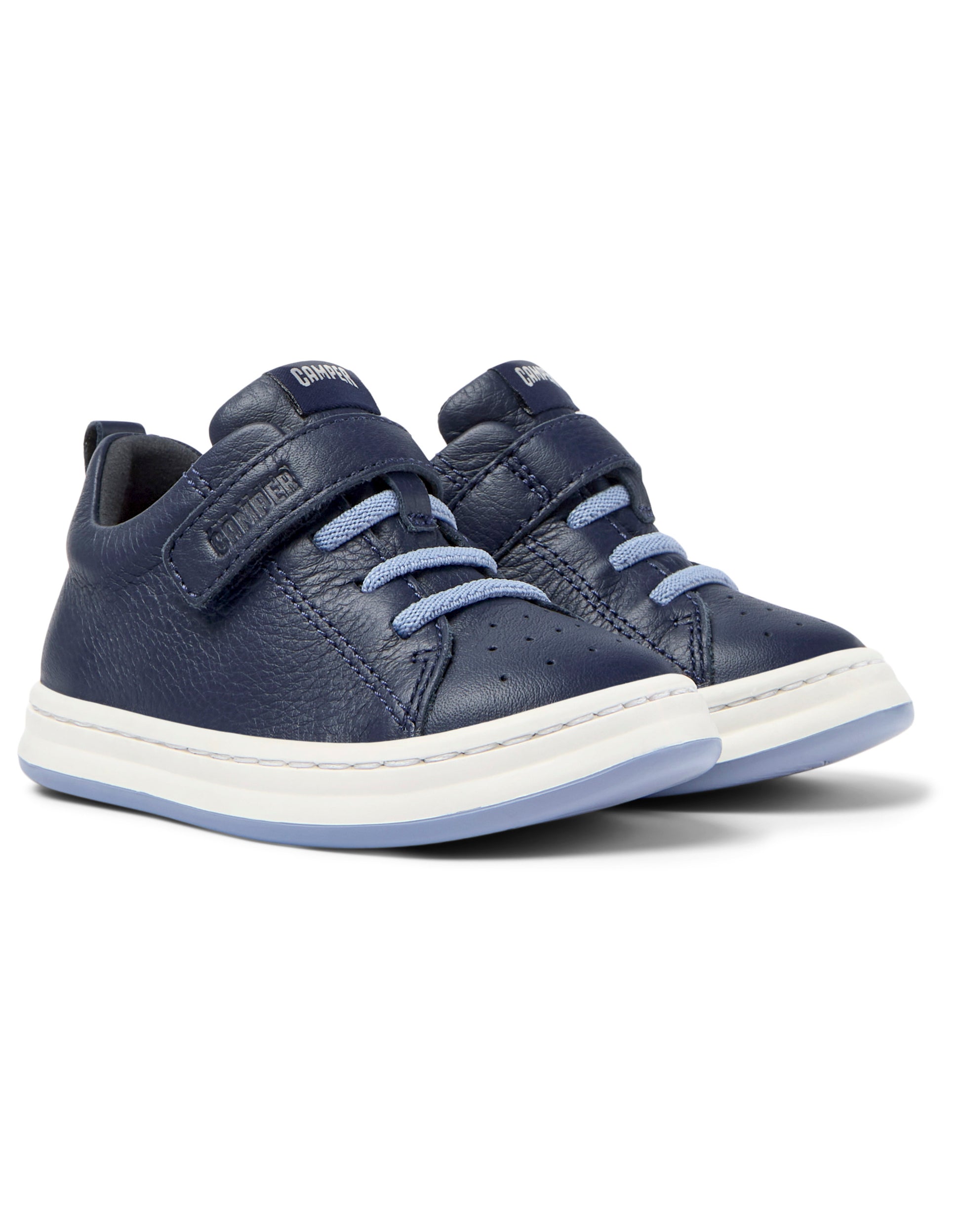 A boys shoe by Camper, style Runner FW, in navy with a velcro strap and light blue elastic laces. Angled view of a pair.