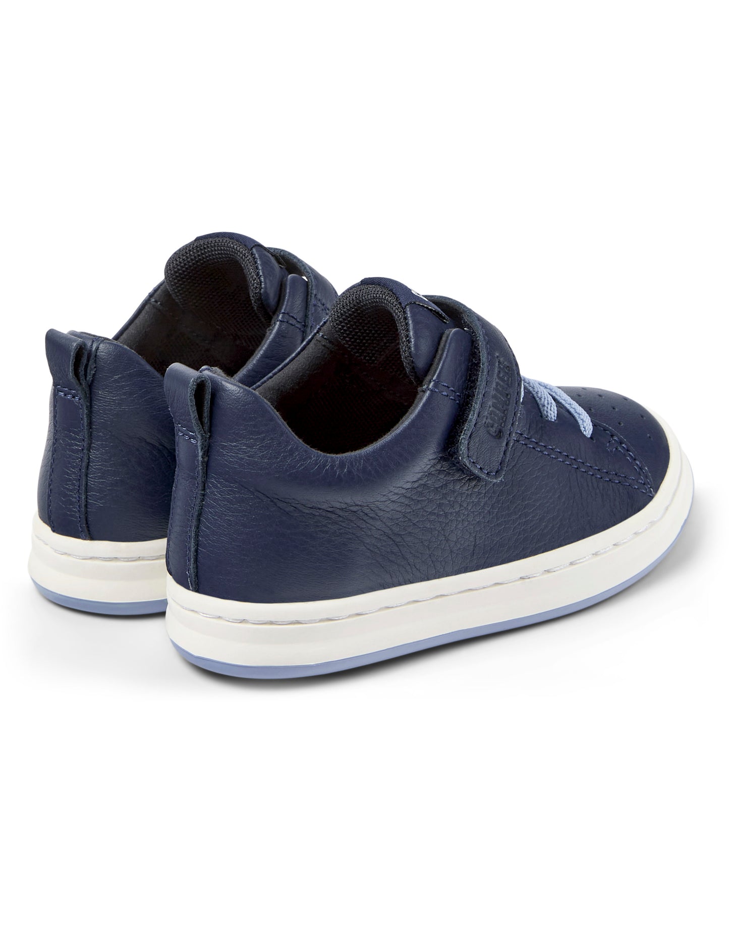 A boys shoe by Camper, style Runner FW, in navy with a velcro strap and light blue elastic laces. Rear angled view of a pair.