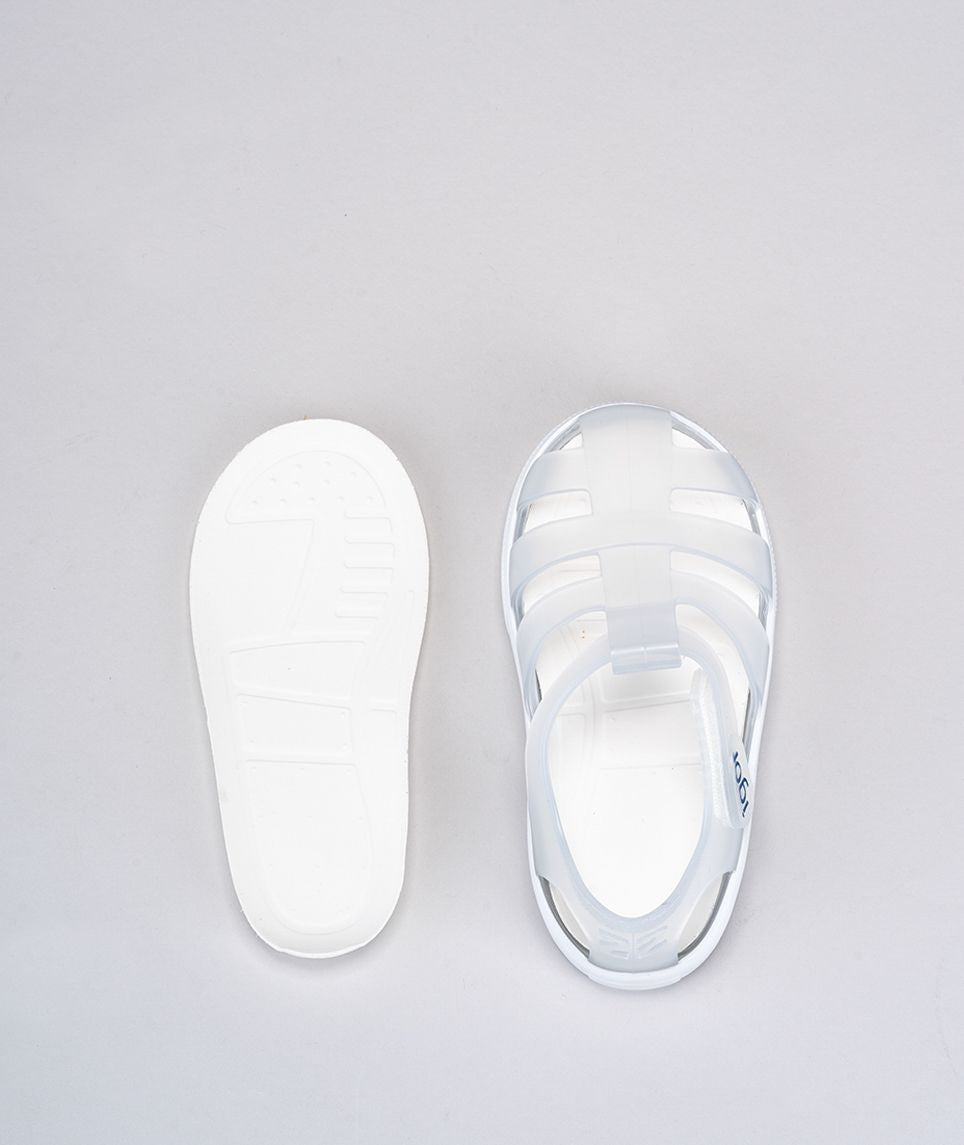 A unisex Jelly shoe by Igor, style Star in clear with a white sole, velcro fastening. View of above right and left sole.
