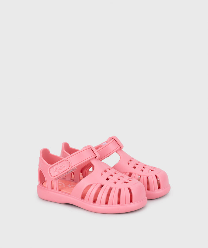 A girls jelly sandal by Igor, style Tobby Solid in Chicle with velcro strap. Angled side view of pair