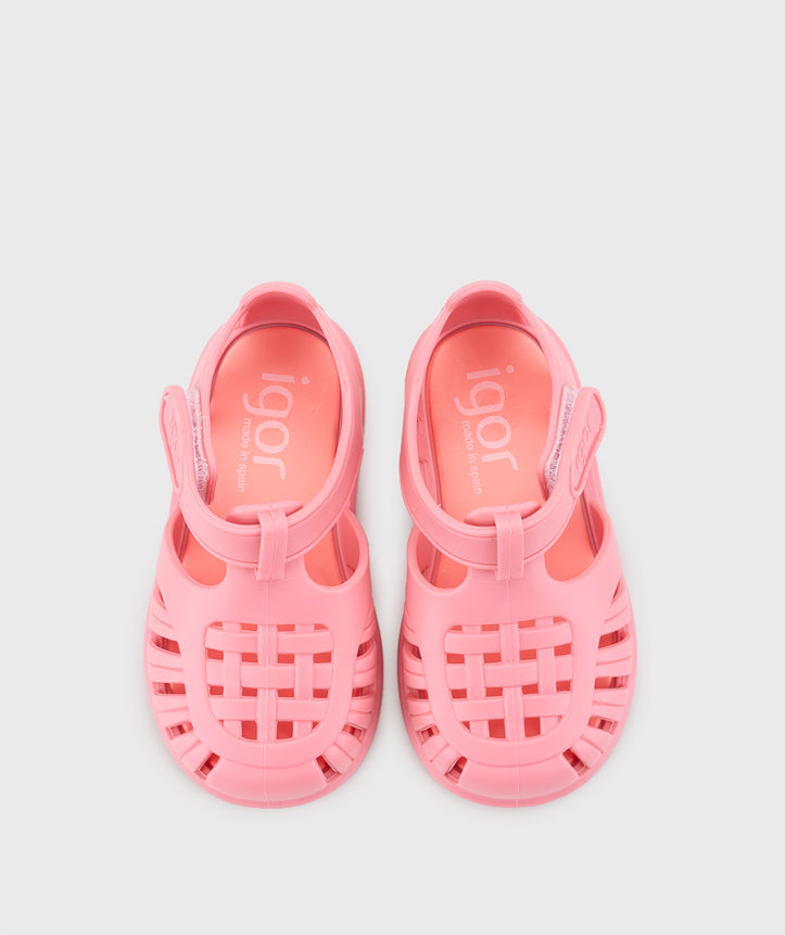 A girls jelly sandal by Igor, style Tobby Solid in Chicle with velcro strap. Angled top view of pair
