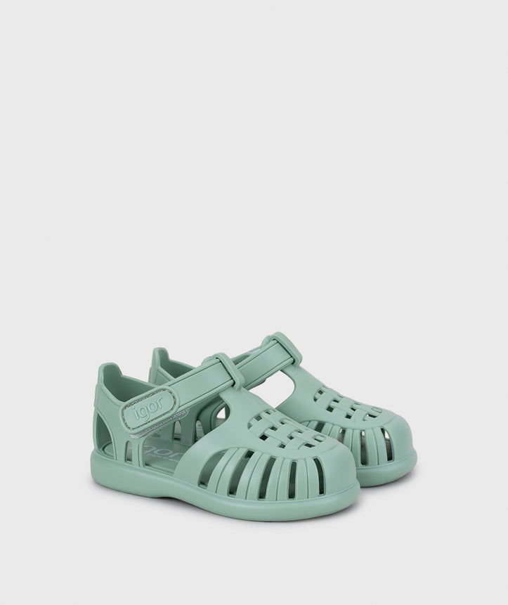 A unisex jelly sandal by Igor, style Tobby Solid in Matcha with velcro strap. Angled side view of pair