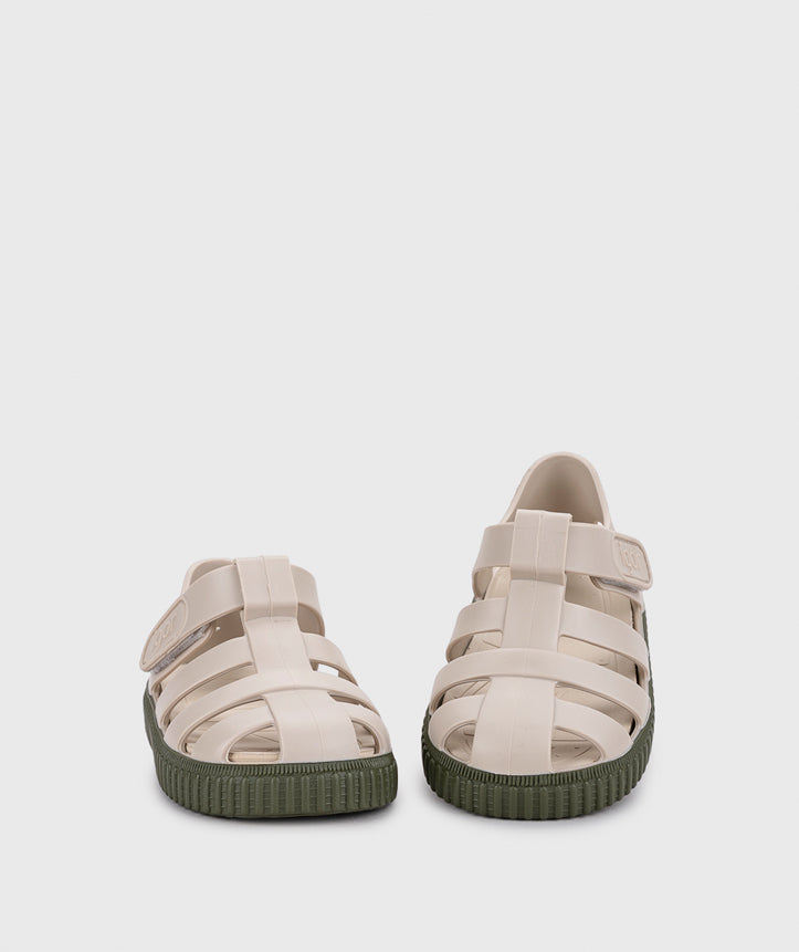 A unisex sandal by Igor, style Nico in khaki with velcro strap and dark green sole. Front view of pair with one slightly elevated