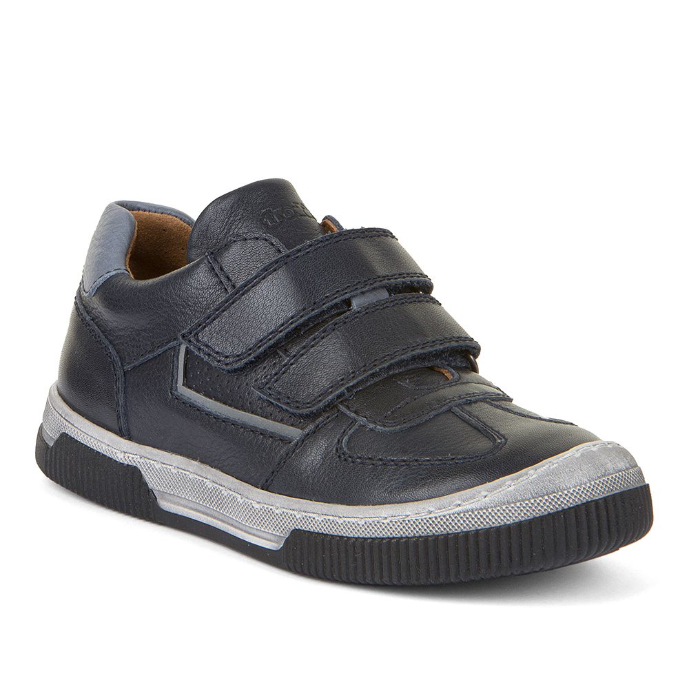 A boys casual shoe by Froddo, style Strike, in navy leather with toe bumper and double velcro fastening. Angled view.