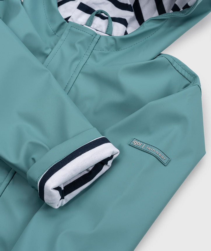 A hooded insulated raincoat by Igor, style Euri, with pockets and white and navy lining. Zip fastening. Close up showing Igor logo.