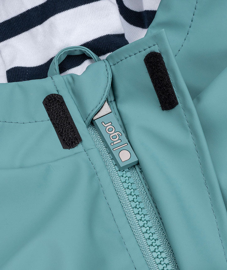 A hooded insulated raincoat by Igor, style Euri, with pockets and white and navy lining. Close up of zip and velcro fastening.