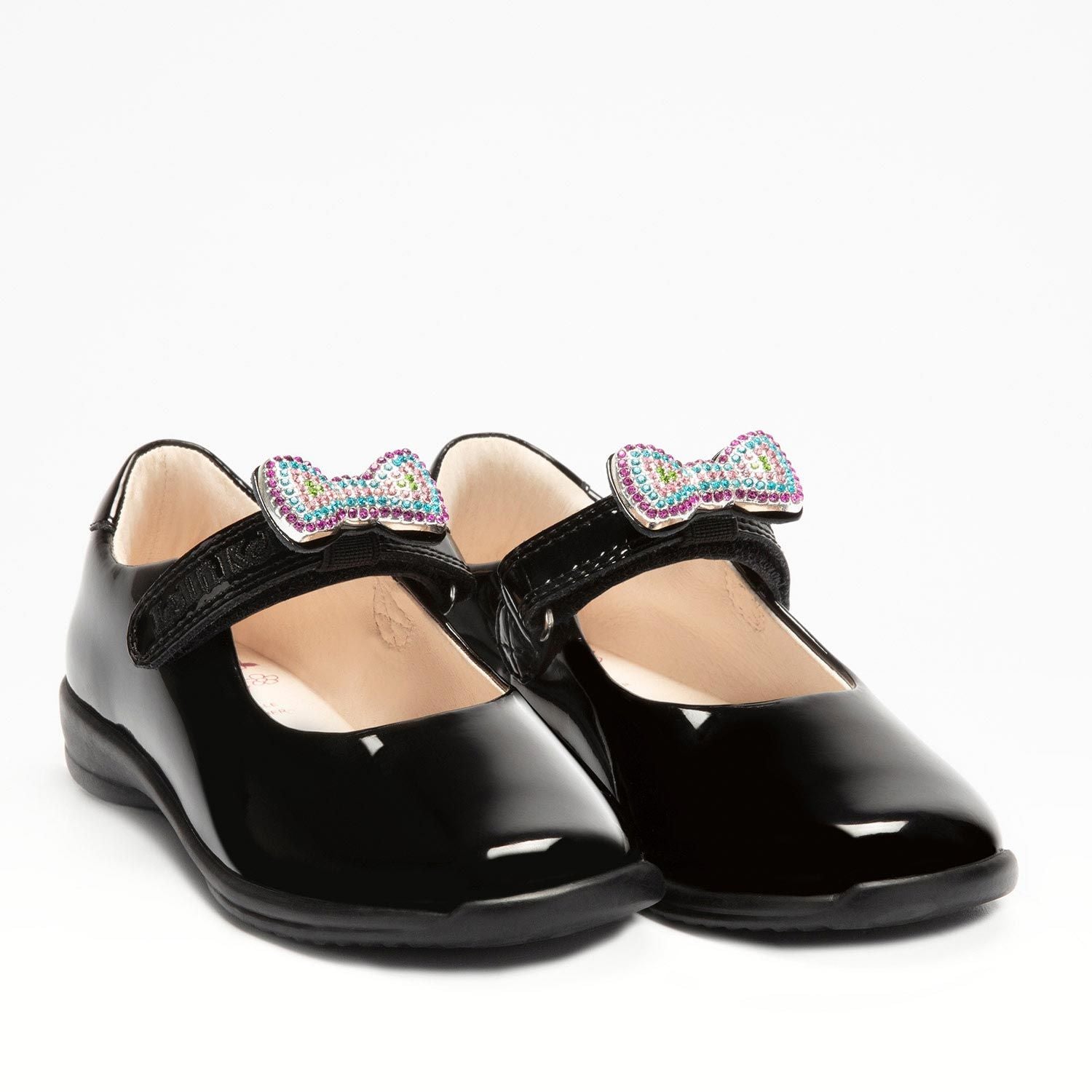 A pair of girls Mary Jane school shoes by Lelli Kelly, style LK8116 Erin, in black patent leather with velcro fastening and detachable multicoloured bow. Angled view.