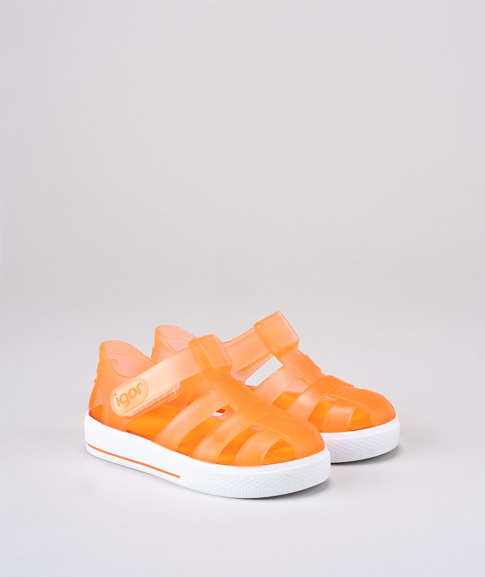 A unisex Jelly shoe by Igor, style Star in orange with a white sole, velcro fastening. Angled view of a pair.